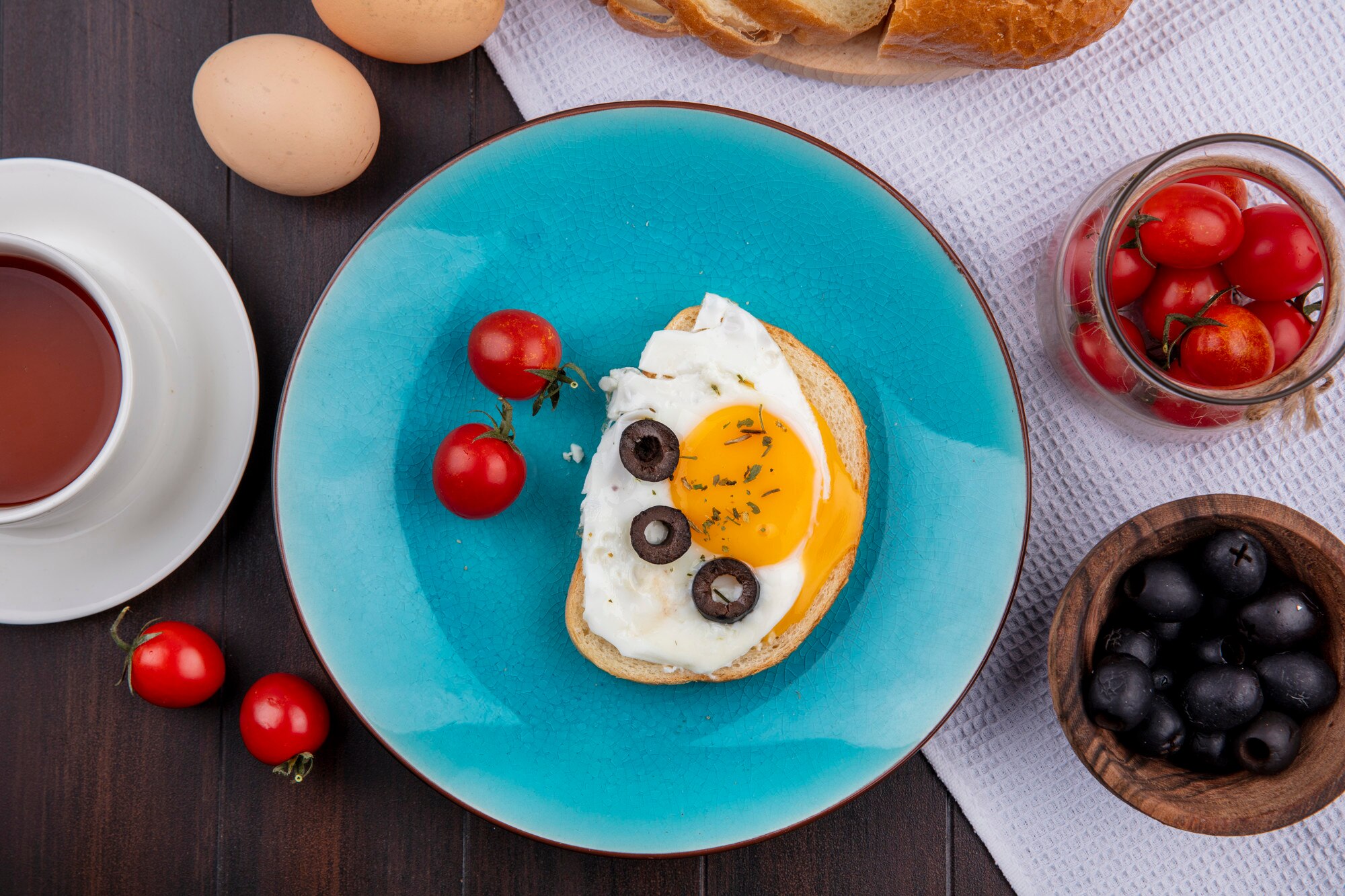 top view fried egg with tomatoes olives plate bowls tomato olive bread cloth with eggs tea wood 141793 17420